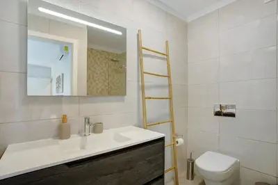 a bathroom with a sink and a toilet and a mirror at Casa Do Tempo com Jacuzzi in Ribeira Brava