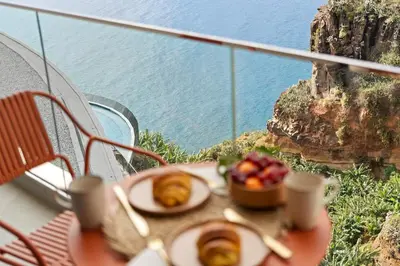 a table with two plates of food and a bowl of fruit at Peace Haven III in Câmara de Lobos