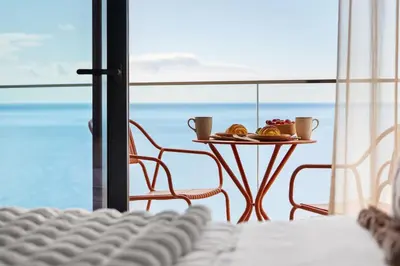a table with a plate of fruit on a balcony at Peace Haven III in Câmara de Lobos