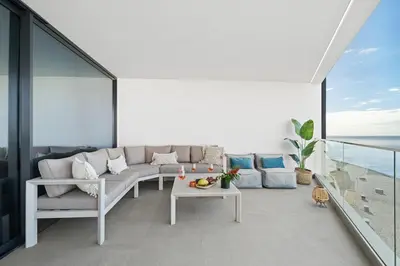 a living room with a couch and a table on a balcony at Peace Haven III in Câmara de Lobos