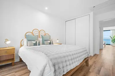 a white bedroom with a large bed and a window at Peace Haven III in Câmara de Lobos