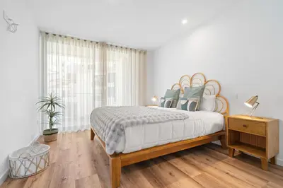 a white bedroom with a bed and a window at Peace Haven III in Câmara de Lobos