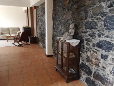 a hallway with a stone wall with a statue on a shelf at House in the montain Casa do Cabeço in Machico