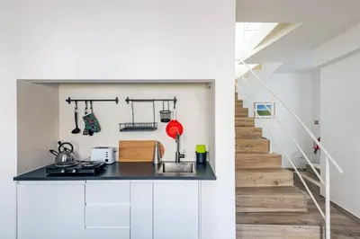 a kitchen with white cabinets and a staircase at Casa do Bispo in Vila do Bispo
