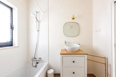 a bathroom with a sink and a tub and a mirror at Casa do Bispo in Vila do Bispo