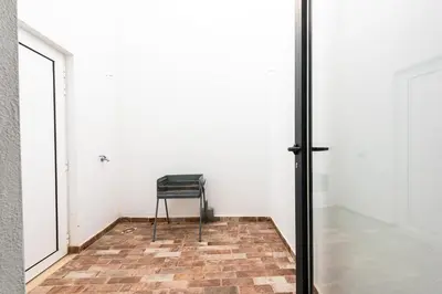 a room with a chair and a glass door at Casa do Bispo in Vila do Bispo