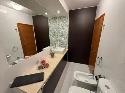 a bathroom with a sink and a toilet and a mirror at Praia da Luz - Resort in Luz