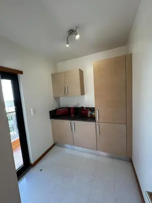 an empty kitchen with wooden cabinets and a window at Praia da Luz - Resort in Luz