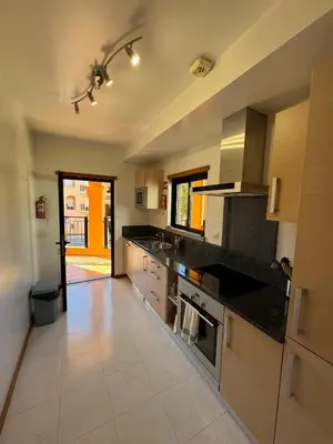 a kitchen with black counter tops and a large appliance at Praia da Luz - Resort in Luz