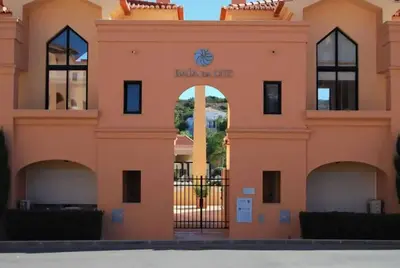 a pink building with an arch in front of it at Praia da Luz - Resort in Luz