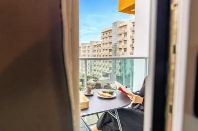 a person sitting at a table with a plate of food looking out a window at Formosa Stay IV by YOUR KEY in Funchal