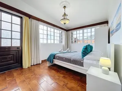 a bedroom with a large bed and windows at Casa Moreira by AH in Caniçal