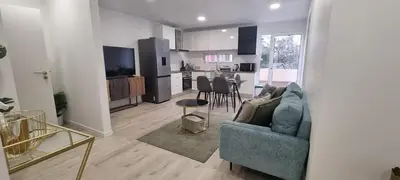a living room with a couch and a kitchen at Charming little house in Paul do Mar