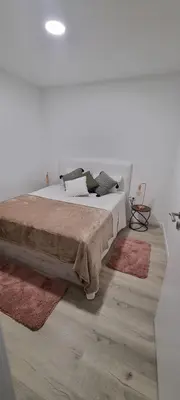 a bedroom with a large bed with rugs on it at Charming little house in Paul do Mar