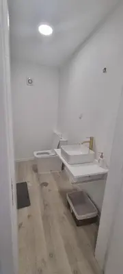 a white bathroom with a toilet and a sink at Charming little house in Paul do Mar
