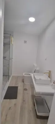 a white bathroom with a toilet and a mirror at Charming little house in Paul do Mar
