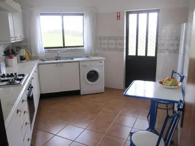 a kitchen with a sink and a washing machine at Villa Figueira in Figueira