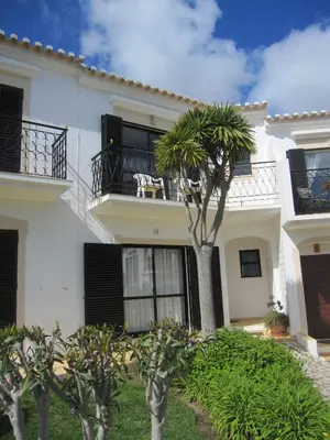 a white house with a palm tree in front of it at Villa Figueira in Figueira