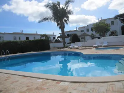 a swimming pool in a yard with a palm tree at Villa Figueira in Figueira