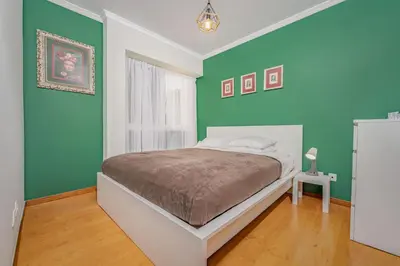 a bedroom with green walls and a white bed at Madeira Dreams in Caniço