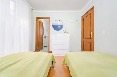 a white room with two beds and a door at Madeira Dreams in Caniço