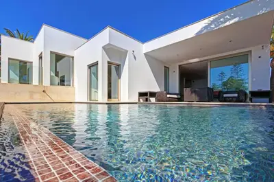 a swimming pool in front of a house at Jacaranda Beach Villa in Luz