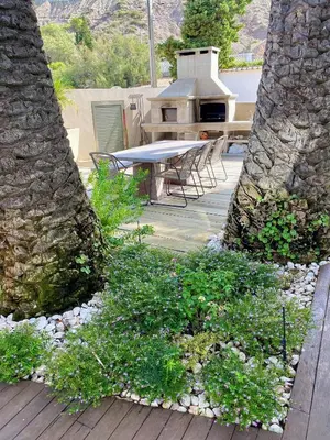 a patio with a table and chairs on a wooden deck at Jacaranda Beach Villa in Luz