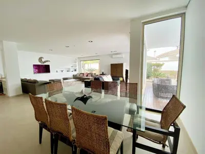 a dining room with a glass table and chairs at Jacaranda Beach Villa in Luz