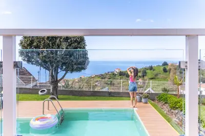 a woman standing next to a swimming pool at Villa Piedade by Homie in Canhas