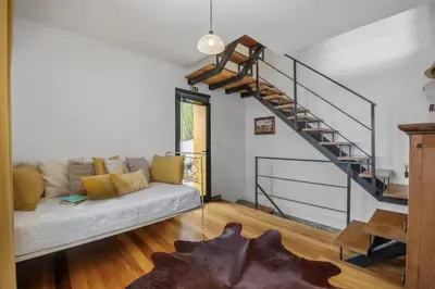 a living room with a couch and a staircase at Villa Piedade by Homie in Canhas