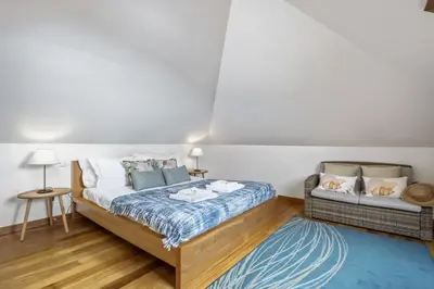 a bedroom with a bed and a chair in it at Villa Piedade by Homie in Canhas