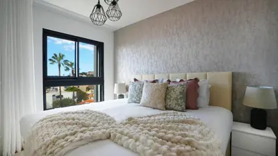 a bedroom with a large white bed with a large window at Meeresbrise by LovelyStay in Caniço