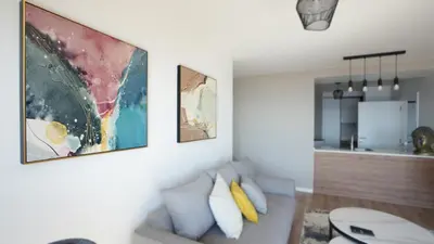 a living room with a couch and paintings on the wall at Meeresbrise by LovelyStay in Caniço