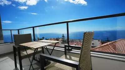 a balcony with a table and chairs and a view at Meeresbrise by LovelyStay in Caniço