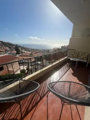 a balcony with two tables and a view of the ocean at Cantinho dos M&M in Funchal