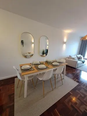 a dining room with a table and two mirrors at Cantinho dos M&M in Funchal