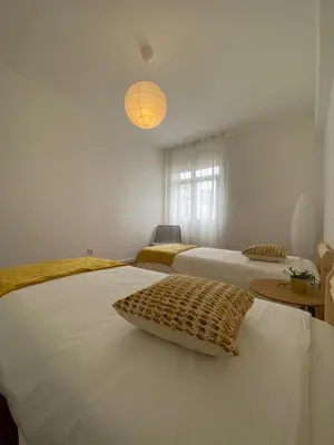 a bedroom with two beds and a pendant light at Cantinho dos M&M in Funchal
