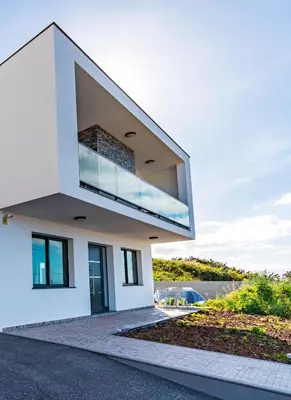 a white house with a large window on it at Casa Luciano in Estreito da Calheta