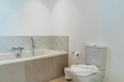 a bathroom with a tub and a toilet and a sink at Casa Luciano in Estreito da Calheta