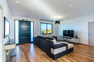 a living room with a couch and a television at Casa Luciano in Estreito da Calheta