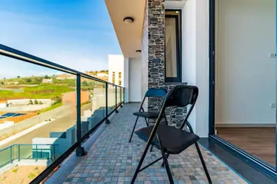 a balcony with two chairs on top of a building at Casa Luciano in Estreito da Calheta