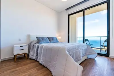a bedroom with a bed with a view of the ocean at Casa Luciano in Estreito da Calheta