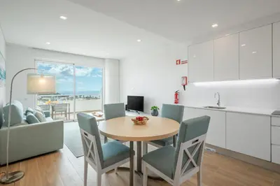 a kitchen and dining room with a table and chairs at Green Beach Ocean View, Porto de Mós VR13 in Lagos