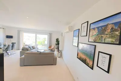 a living room with a couch and a tv on a wall at Home By The Sea Ocean View Apartment in Lagos