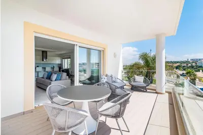 a living room with a table and chairs on a balcony at Home By The Sea Ocean View Apartment in Lagos