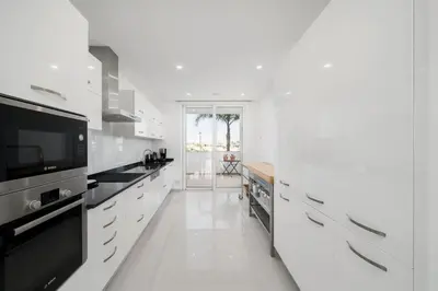 a white kitchen with white cabinets and a tv at MaBelle Luxury Ocean View Apartment in Lagos