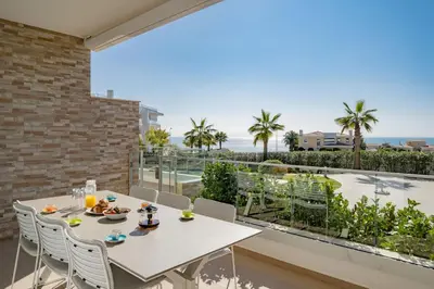 a table and chairs on a balcony with a view of the ocean at MaBelle Luxury Ocean View Apartment in Lagos