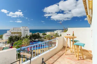 a balcony with a table and chairs and the ocean at Shabby Chique Surf Beach and Ocean in Luz