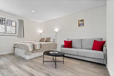 a white living room with a couch and a table at Studio Carmo in Funchal