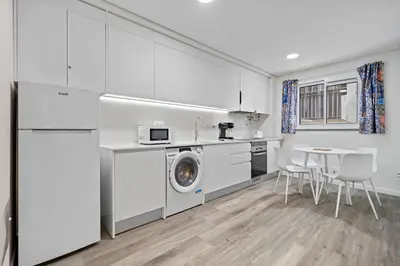 a kitchen with a washing machine and a table at Studio Carmo in Funchal